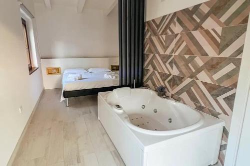 a white bath tub in a room with a bed at Resort Petrasia in Villammare