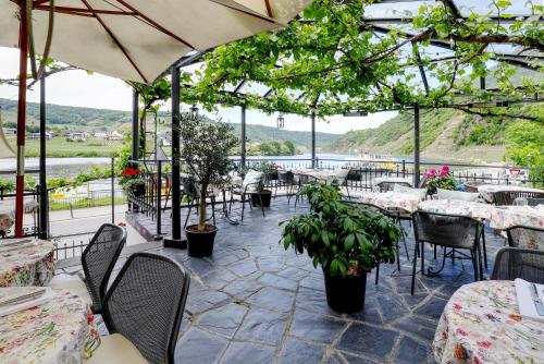 a restaurant with tables and chairs with a view of the water at Hotel Lipmann "Am Klosterberg" in Beilstein
