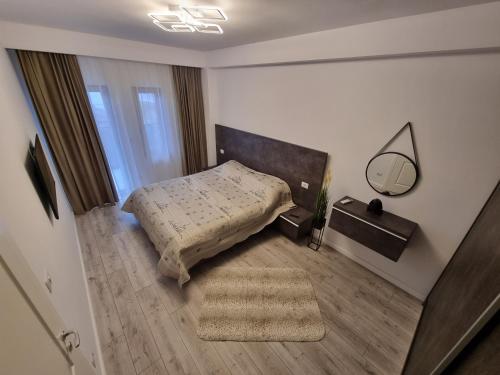 ein kleines Schlafzimmer mit einem Bett und einem Spiegel in der Unterkunft Apartament Mihai Cassas Residence in Craiova