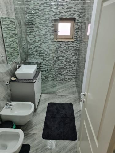 ein Bad mit einem Waschbecken, einem WC und einer Dusche in der Unterkunft Apartament Mihai Cassas Residence in Craiova