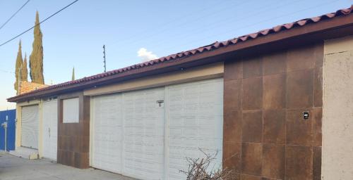 a row of four garage doors on a building at Suites Pozos Mágico in San Luis de la Paz