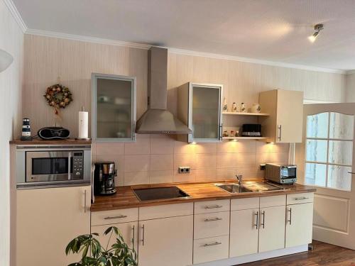 cocina grande con armarios blancos y fregadero en Ferienwohnung Seerose en Sassnitz