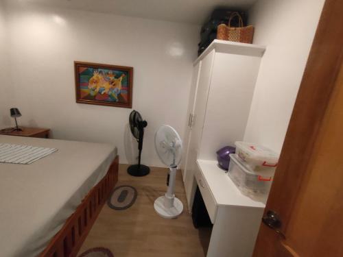 1 dormitorio con 1 cama y escritorio con ventilador en Johansen's Residence, en San Juan