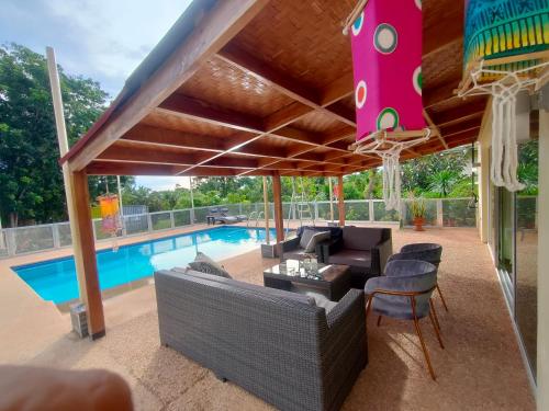 un patio con sofá y sillas junto a la piscina en Johansen's Residence, en San Juan