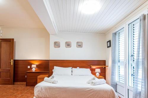 a bedroom with a large bed with a wooden headboard at Villa Sophia in Caleta De Fuste