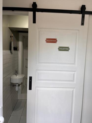 a white door with two signs on it in a bathroom at Nuit insolite au cœur d’un ranch proche d’Europa park in Schwobsheim