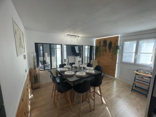a dining room with a black table and chairs at Myhomezen Chessy Disneyland Val d'Europe - 3D PlayStation 4 in Chessy
