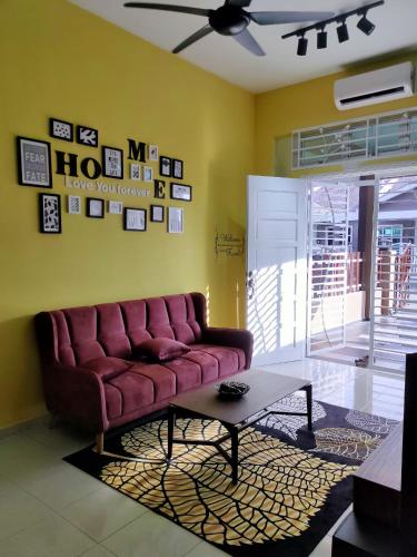 a living room with a red couch and a table at Amani Homestay in Melaka