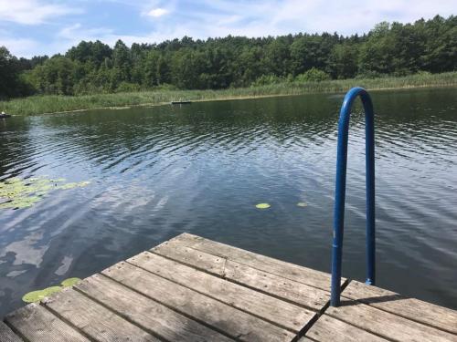 a dock with a blue pole in the water at Belle ILE in Lychen
