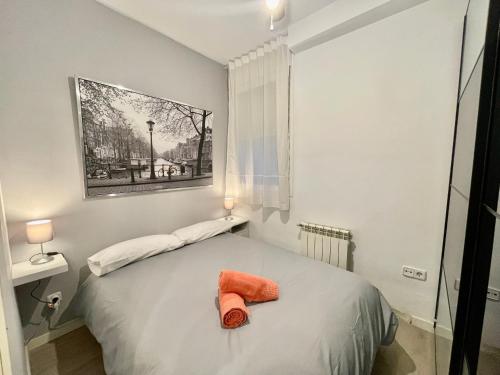 um quarto com uma cama com uma toalha laranja em Bonito apartamento junto a la Plaza Mayor em Madri