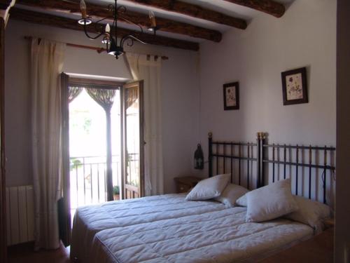 1 dormitorio con cama y ventana grande en Apartamentos Albarcas, en Villares de Jadraque