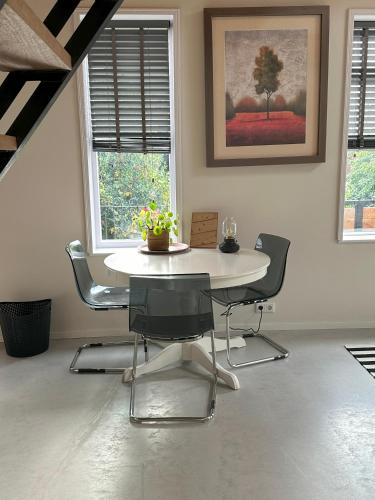 a dining room with a white table and chairs at trendy boutique appartement vlak bij Amsterdam in Rijnsaterwoude