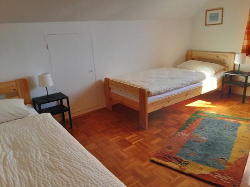 a bedroom with two beds and a rug on a wooden floor at FeWo Christine in Bad Buchau