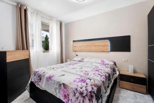 1 Schlafzimmer mit einem Bett mit Blumenbettdecke in der Unterkunft Apto Niky By Paramount Holidays in Adeje