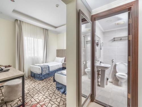 a hotel room with a bathroom with a toilet and a sink at Alayam Elite Hotel in Mecca