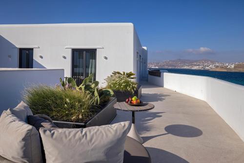 a patio with a couch and a table on a balcony at Aeonic Suites and Spa in Mýkonos City