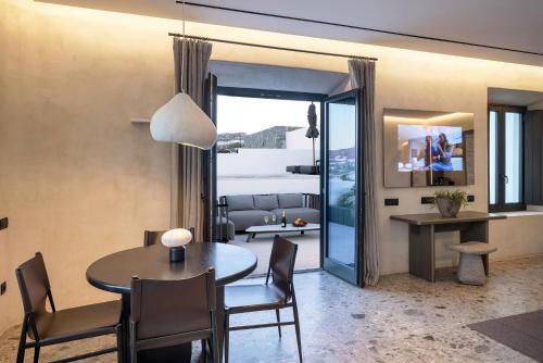 a dining room and living room with a table and chairs at Aeonic Suites and Spa in Mýkonos City