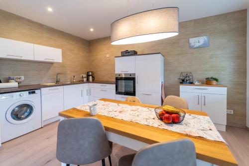 a kitchen with a table with a bowl of fruit on it at Ferienhaus Zum Kuckuck, Wng 2, Urlaub im Eichsfeld in Kallmerode