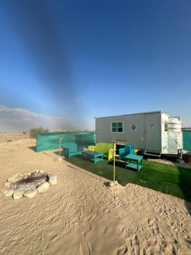 a house in the middle of the desert with a fire pit at Oasis Caravan in Dubai