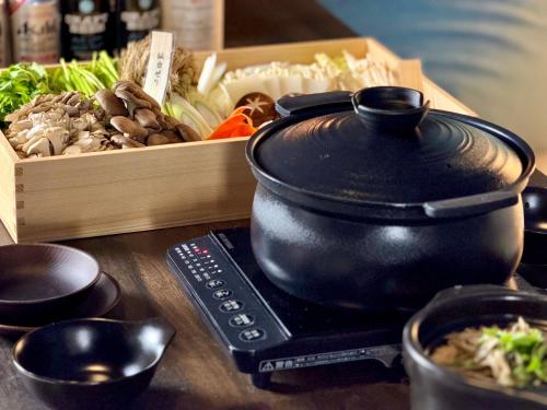 a pot on a stove next to a box of vegetables at chillout glamping zao in Zao