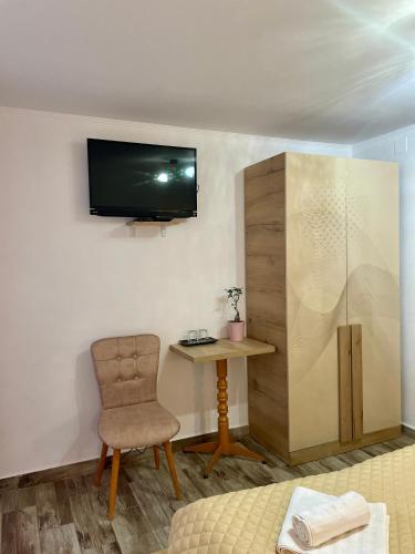 a room with a desk and a chair and a tv at La Turcu in Văliug
