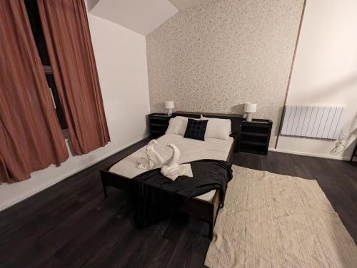 a bedroom with a bed with two swans on it at Stylish Studio Apt at the Rock Bury in Bury