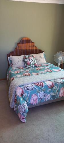 a bed with a colorful blanket and pillows on it at Coco's Hamlet Self Catering Accommodation in Prince Alfreds Hamlet