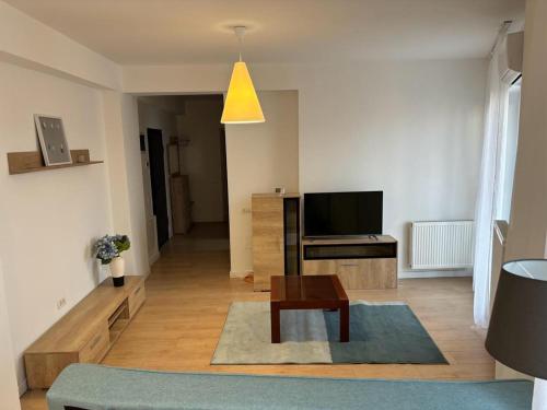 sala de estar con TV y mesa en Apartament luminos, en Voluntari