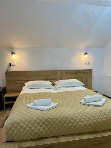 a bedroom with a large bed with towels on it at La Turcu in Văliug