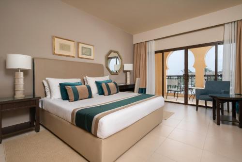 a hotel room with a bed and a balcony at JAZ Oriental, Almaza Bay in Marsa Matruh