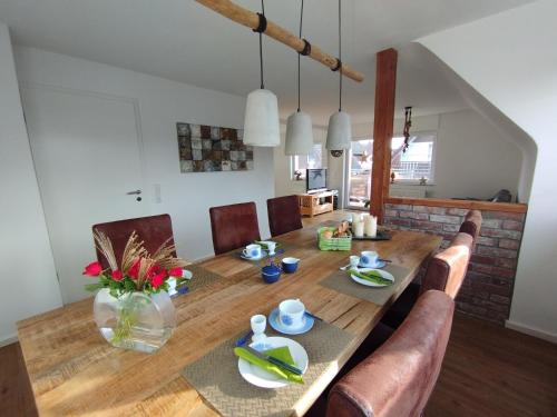 a dining room with a wooden table and chairs at Ferienwohnung Schmidt in Schüttorf