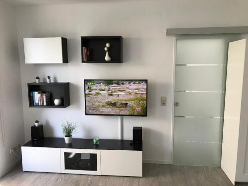 a living room with a tv on a wall at FeWo Malum, Sonniges Apartment direkt an der Ostsee in Zierow