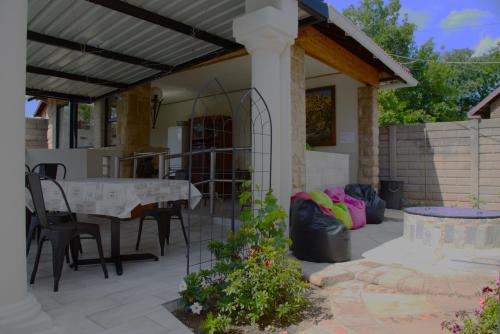 un patio con mesa y sillas. en Xaviera Guest House, en Pretoria