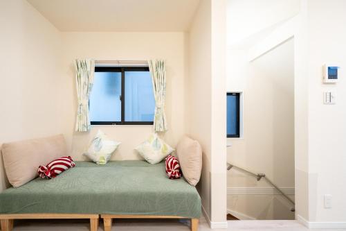 a room with a green couch with a window at Maison Novel under Skytree in Tokyo