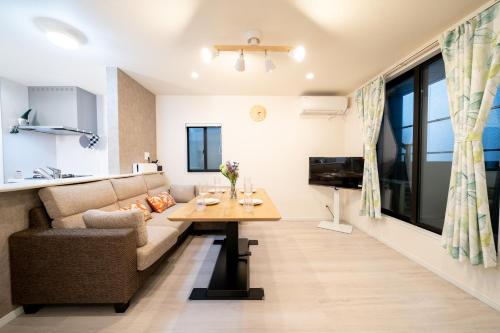 a living room with a couch and a table at Maison Novel under Skytree in Tokyo
