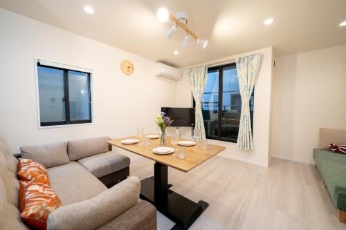 a living room with a table and a couch at Maison Novel under Skytree in Tokyo