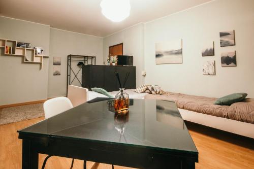 ein Wohnzimmer mit einem Tisch und einem Bett in der Unterkunft Appartamento Castelli - Affitti Brevi Italia in Varese