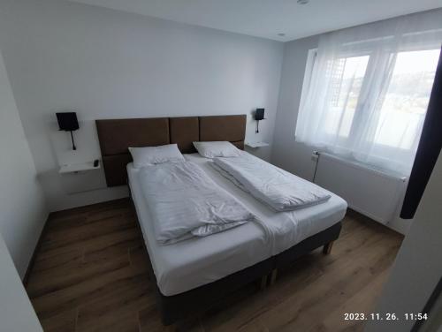 a bedroom with a bed with white sheets and a window at Apartment Feldkirch in Feldkirch