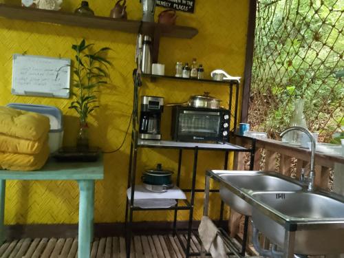 een keuken met een wastafel en een magnetron bij Camp Talusi Hills Overlooking in El Nido