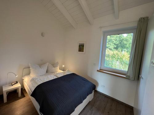 a bedroom with a bed and a window at Ferienhaus Auszeit mit Sauna in Schwarz