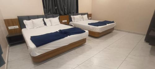two beds sitting in a room with at Hotel Purushottam in Dwarka
