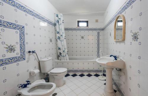 a bathroom with a toilet and a sink and a tub at Casa Bellarosa in Raposeira
