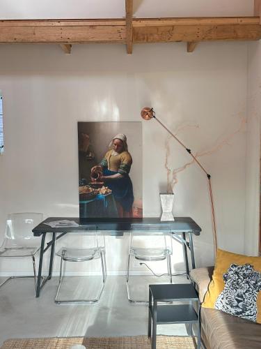 a table in a living room with a painting on the wall at Boutique appartement vlak bij Amsterdam in Rijnsaterwoude