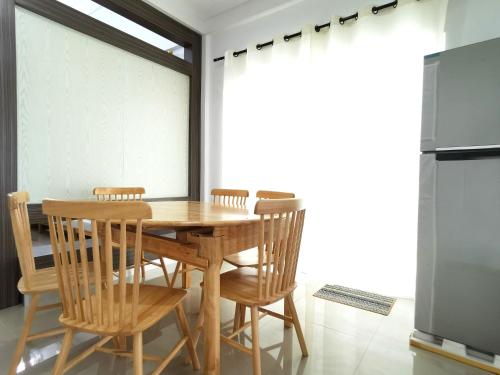 a dining room with a wooden table and chairs at pen kyu house1 in Kota Samarahan