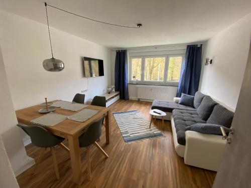 ein Wohnzimmer mit einem Tisch und einem Sofa in der Unterkunft Ferienwohnungen an der Schlösselmühle in Amtsberg