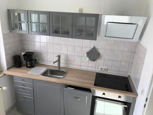 a small kitchen with a sink and a stove at FeWo Malum, Sonniges Apartment direkt an der Ostsee in Zierow