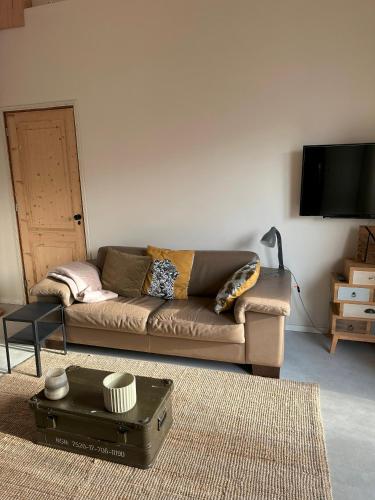 a living room with a couch and a tv at Boutique appartement vlak bij Amsterdam in Rijnsaterwoude
