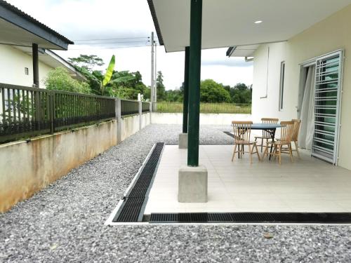 a patio with chairs and a table in a house at pen kyu house1 in Kota Samarahan