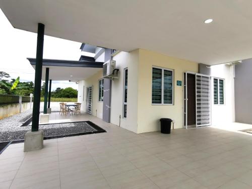 a white house with a courtyard with a patio at pen kyu house1 in Kota Samarahan