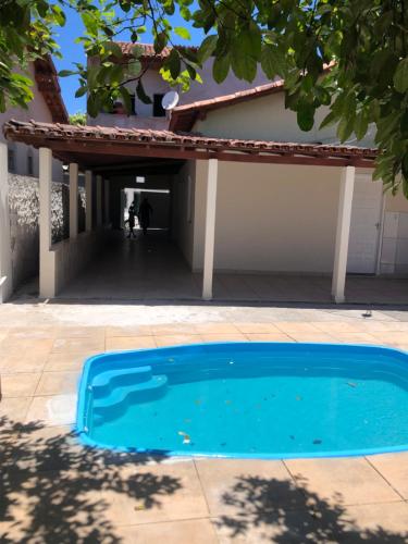 a blue swimming pool in front of a house at Casa praia alcobaca 3 quartos in Alcobaça
